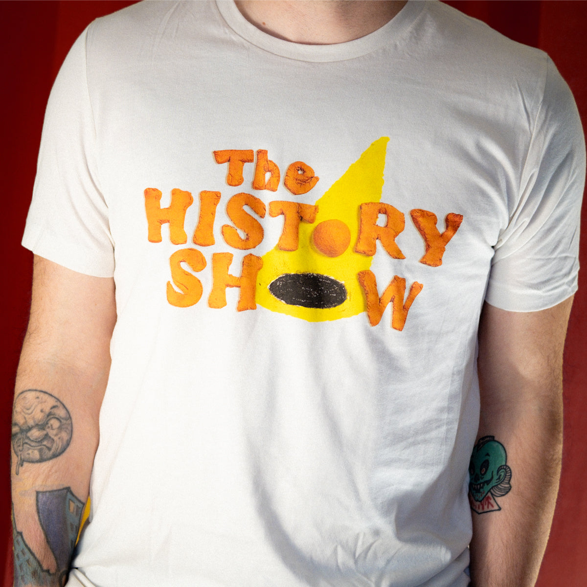 A zoomed-in photo of someone wearing The History Show handmade logo shirt.
