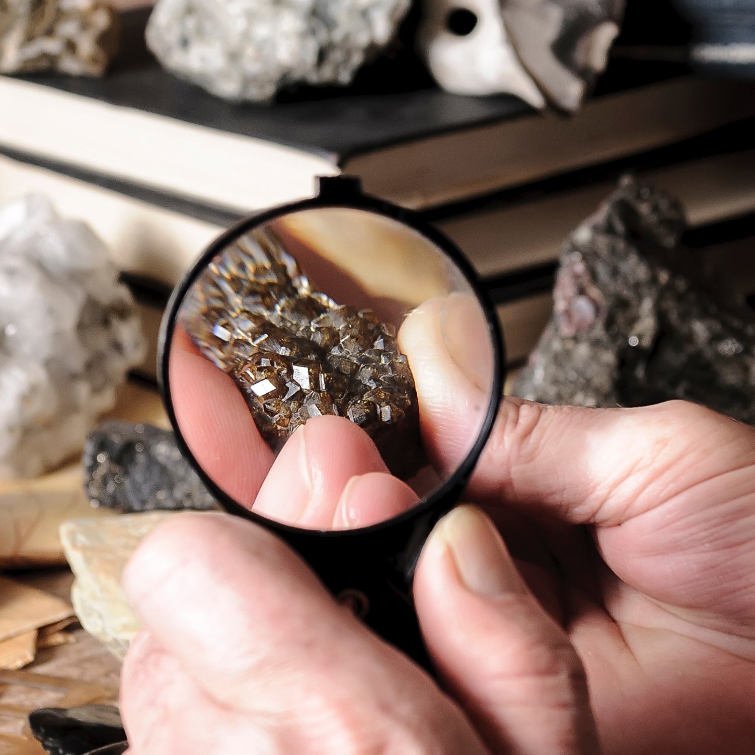 Geologist examining minerals by hand with a magnifying glass